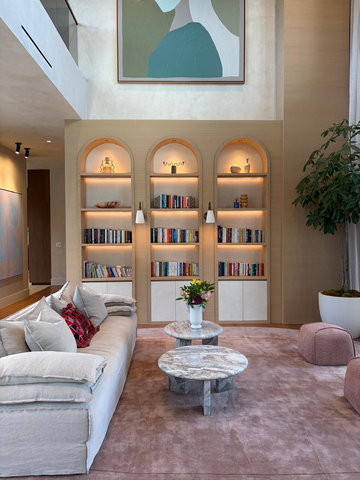 Detail of arched built-in bookshelves in a double-height living room
