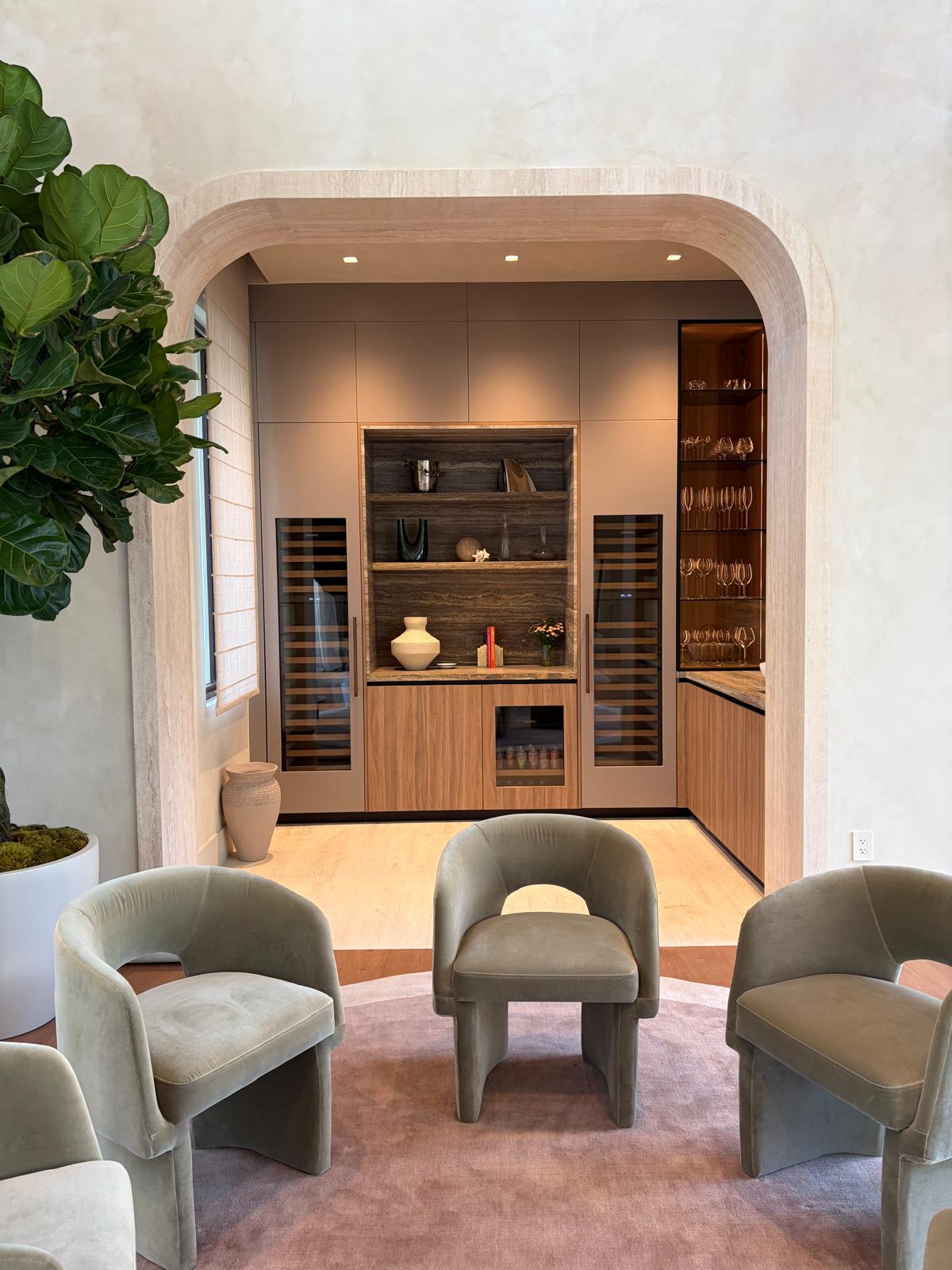 Lounge with leather club chairs framed by an arched entry onto the bar